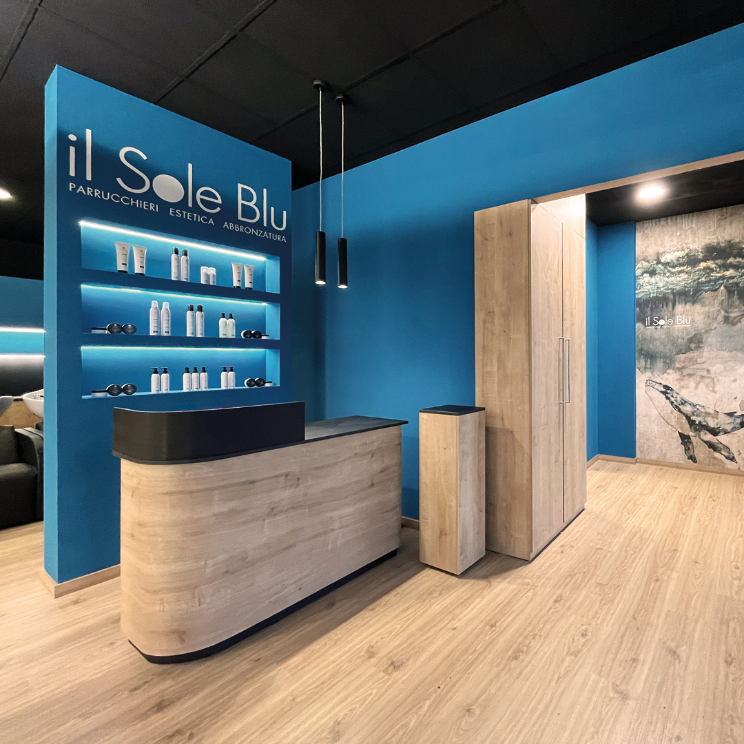 Immagine area reception molto spaziosa con mobili in legno e pareti blu 